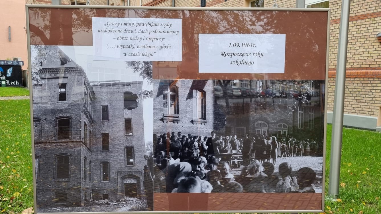 Tablica ze zdjęciami zrujnowanego budynku szkolnego oraz  dziećmi i dorosłymi. Zdjęcia uzupełniają informacje na kartkach.