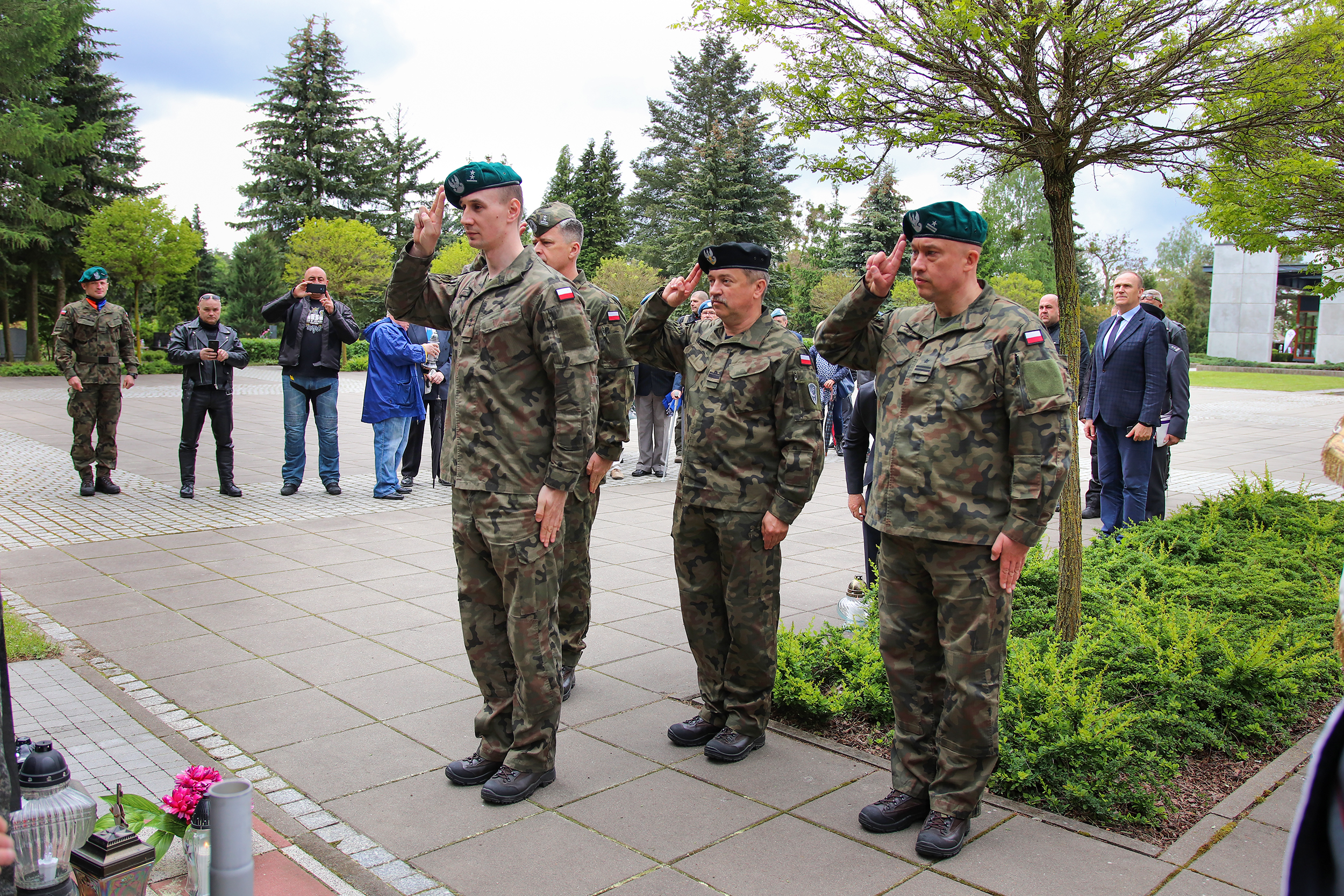 żołnierze salutują przed pomnikiem, ludzie w tle robią zdjęcia