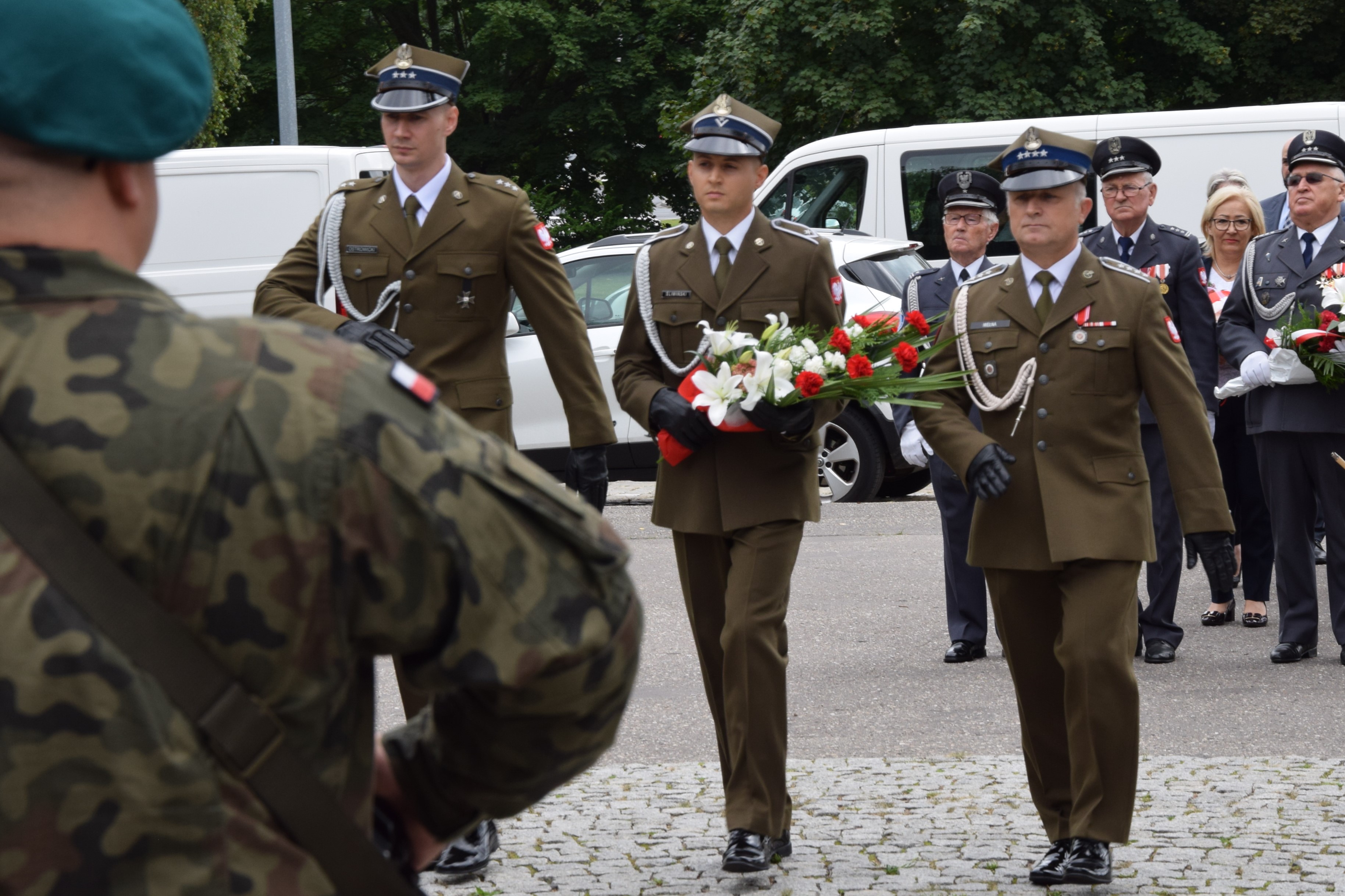 delegacja 3 żołnierzy maszeruje w stronę pomnika
